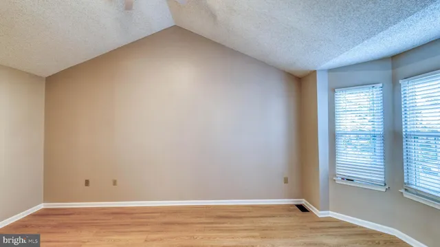 a view of a room with wooden floor and a window