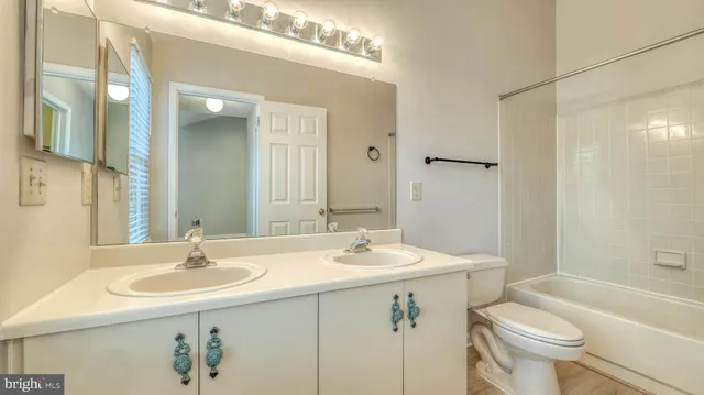 a bathroom with a sink toilet and a mirror