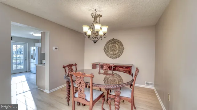 a view of a dining room with furniture and chandelier