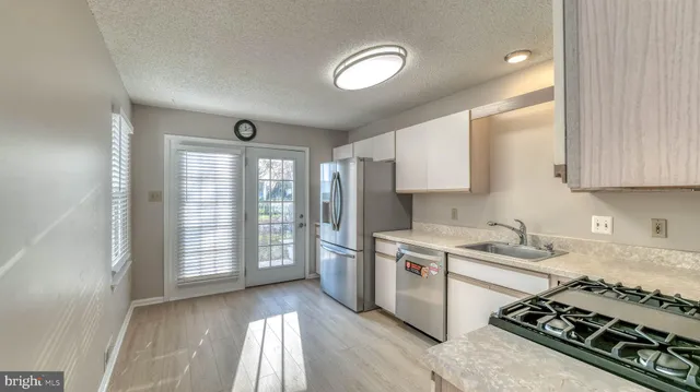 a kitchen that has a sink stainless steel appliances counter space and a window