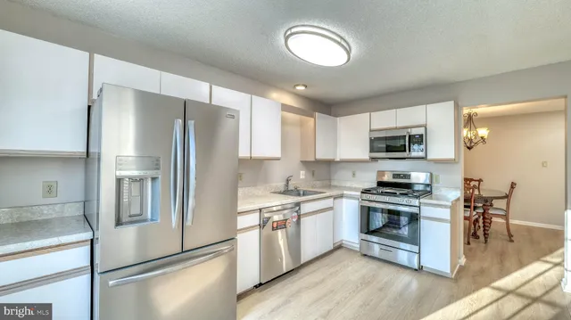 a kitchen with stainless steel appliances granite countertop a stove a refrigerator and a refrigerator