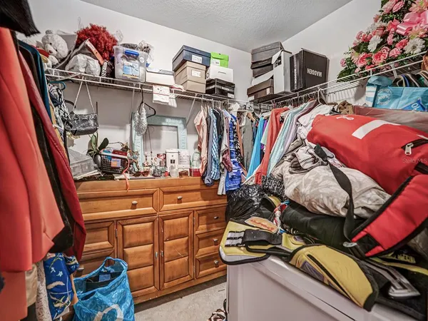 a view of walk in closet with clothes and shoes
