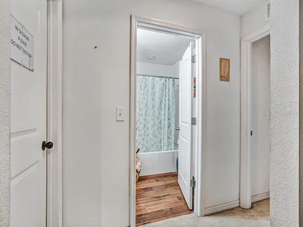 a view of a hallway with wooden floor and closet