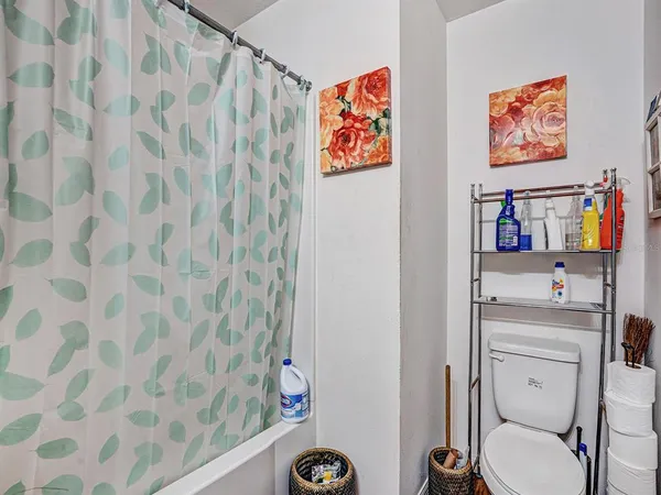 a bathroom with a toilet and a shower curtain