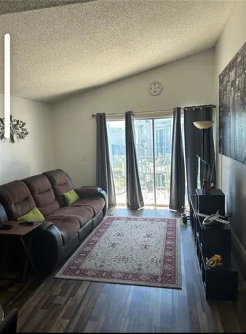 a view of a dining room and livingroom with furniture wooden floor a chandelier
