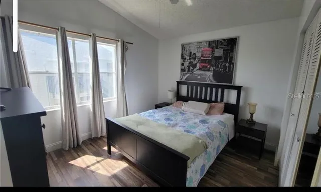 a room with a bed a mirror and a desk