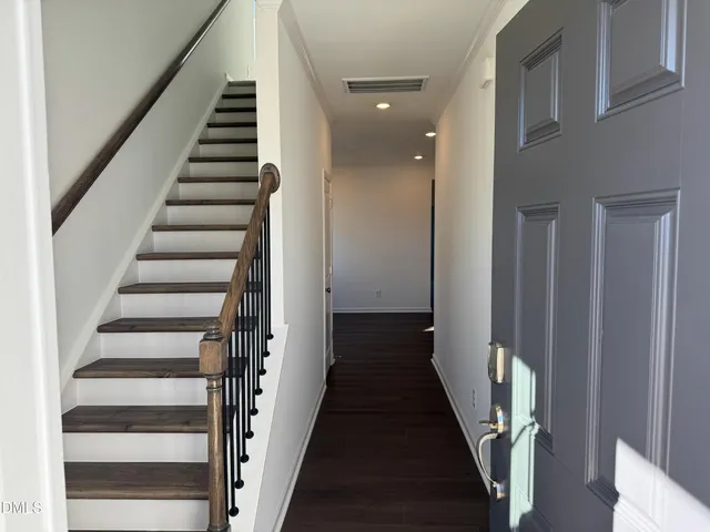 a view of a hallway with wooden floor and entryway