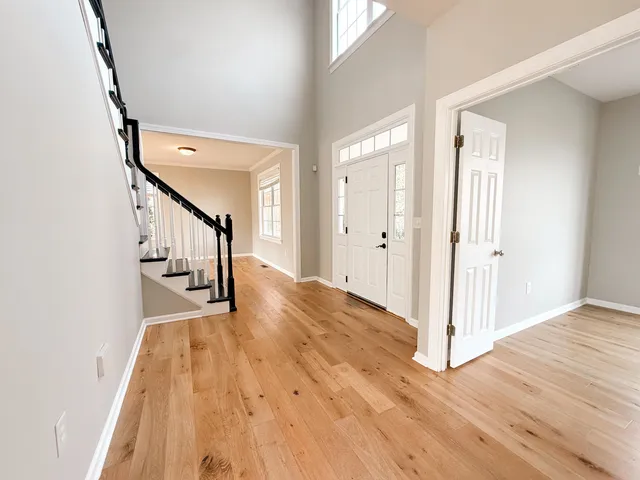 a view of an empty room with window and wooden floor