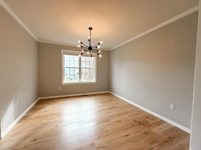 a kitchen with stainless steel appliances granite countertop a refrigerator a sink dishwasher a stove and white countertops with wooden floor