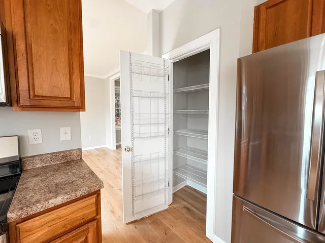 a view of an empty room with a window and a fireplace