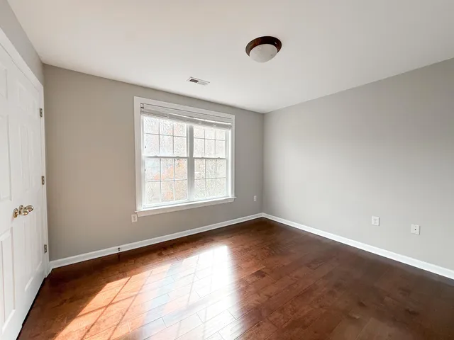 a view of an empty room with wooden floor