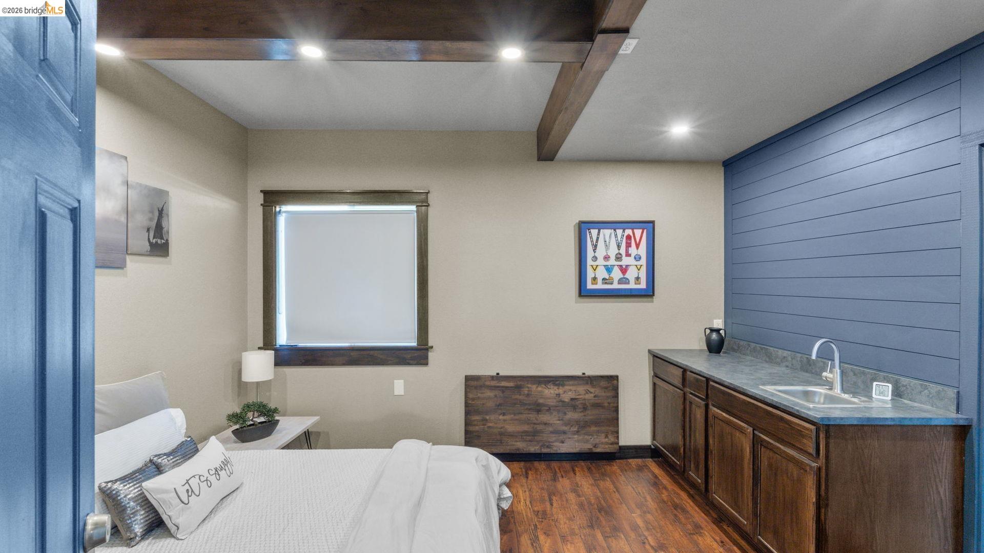 700 Brownstone Road Oakley, CA 94561 - Photo 46 of 58 Interior room featuring wood-finish flooring, exposed ceiling beams with recessed lighting, and a window with a roller shade