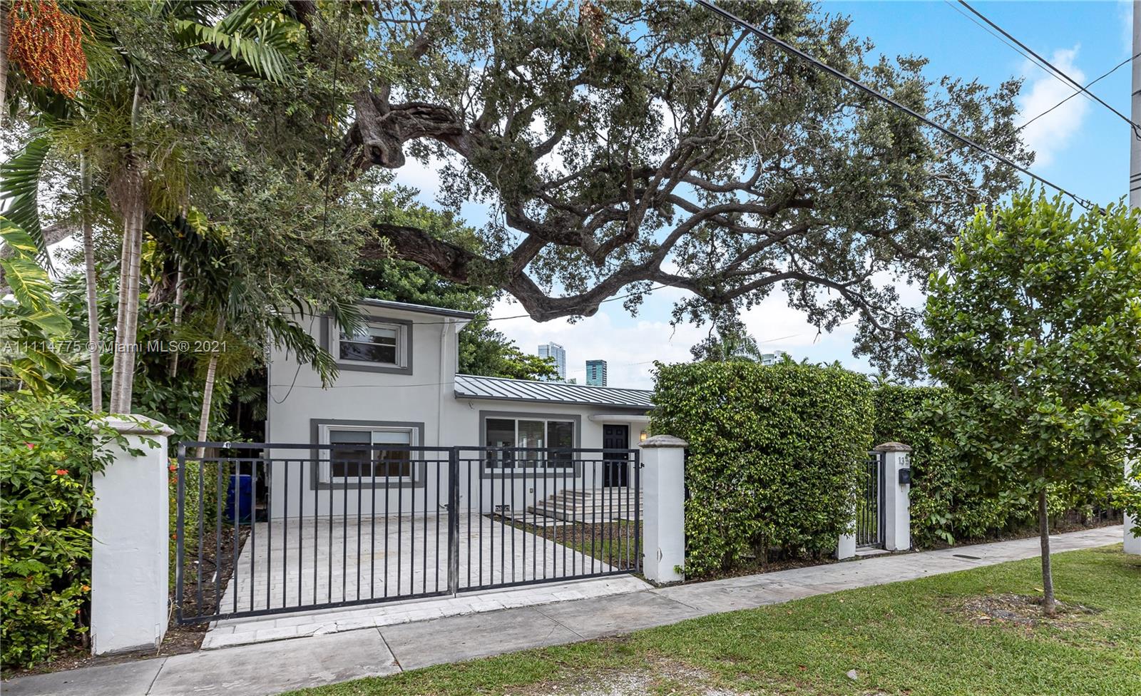 135 Southwest 22nd Road Miami, FL 33129 - Photo 3 of 44 a view of a house with a small yard and a large tree