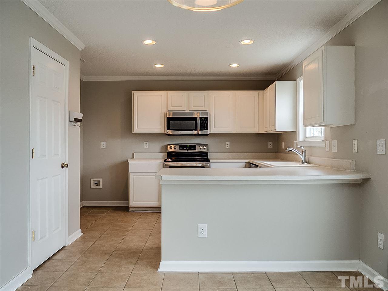7416 Lowell Ridge Road Raleigh, NC 27616 - Photo 2 of 26 a kitchen with a refrigerator and a stove top oven
