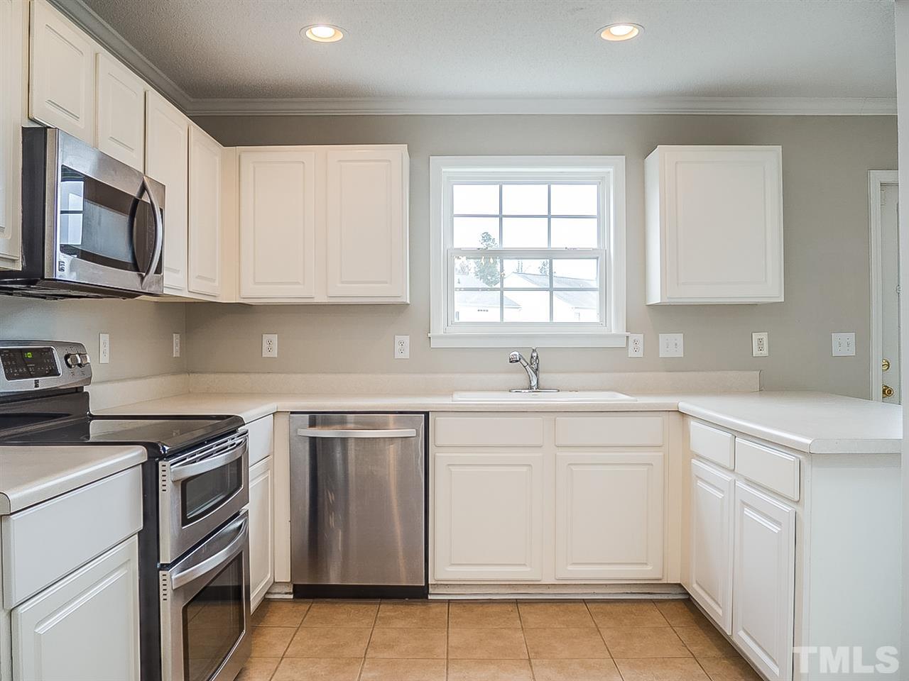 7416 Lowell Ridge Road Raleigh, NC 27616 - Photo 3 of 26 a kitchen with cabinets appliances a sink and a window