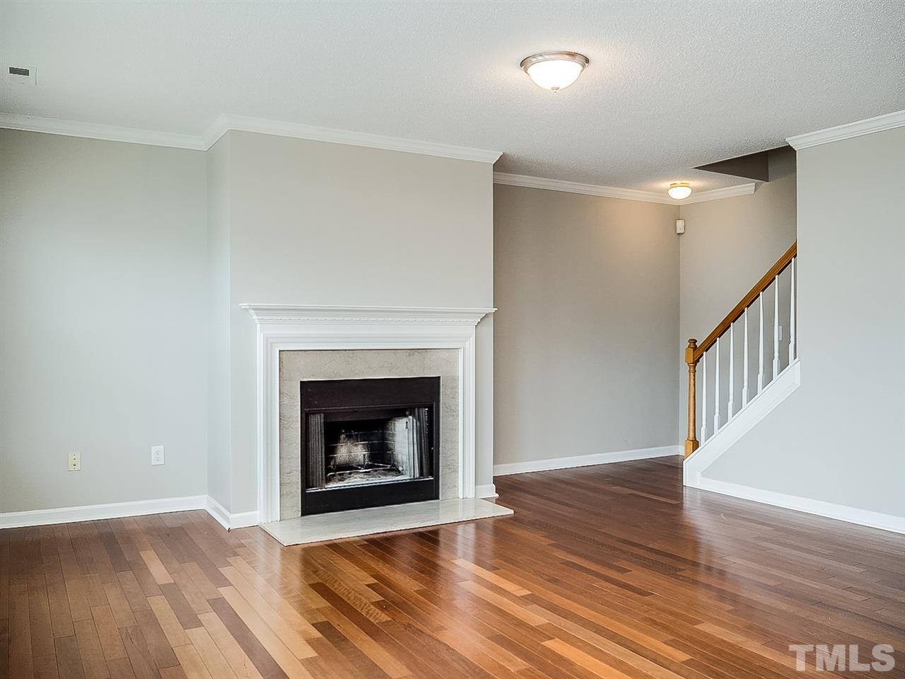 7416 Lowell Ridge Road Raleigh, NC 27616 - Photo 6 of 26 a view of an empty room with wooden floor fireplace and a window