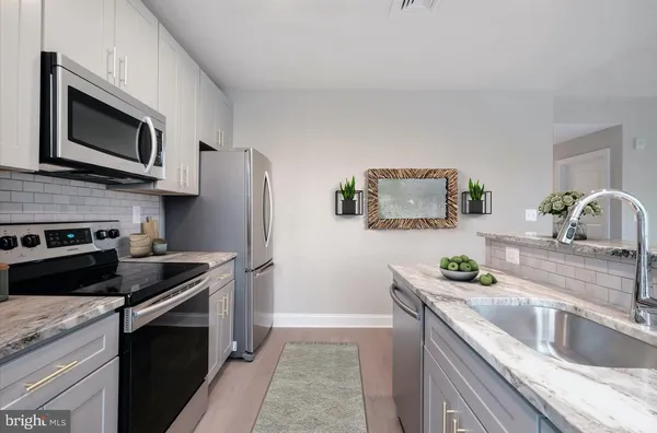 a kitchen with stainless steel appliances granite countertop a sink stove and microwave