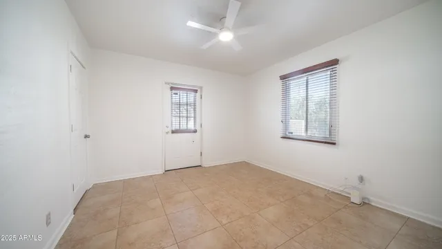 an empty room with windows and fan