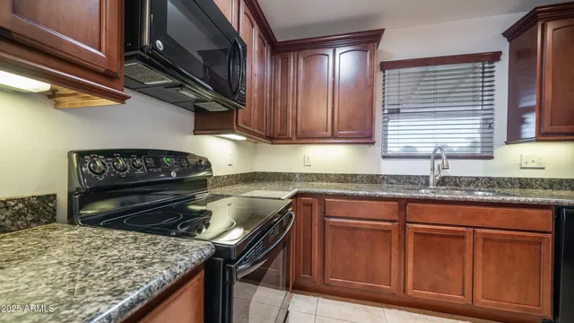 a kitchen with granite countertop a stove and a sink