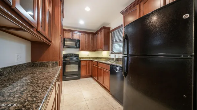 a kitchen with stainless steel appliances granite countertop a refrigerator and a stove