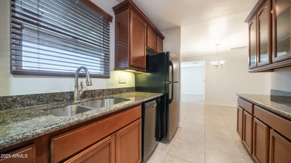 a kitchen with granite countertop a sink and a refrigerator