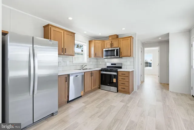 a kitchen with stainless steel appliances a refrigerator sink and microwave