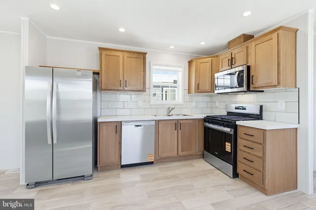 a kitchen with stainless steel appliances granite countertop a refrigerator sink and stove