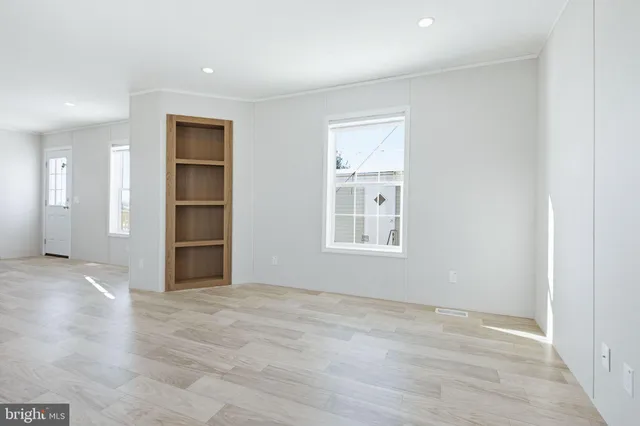 an empty room with windows and cabinet