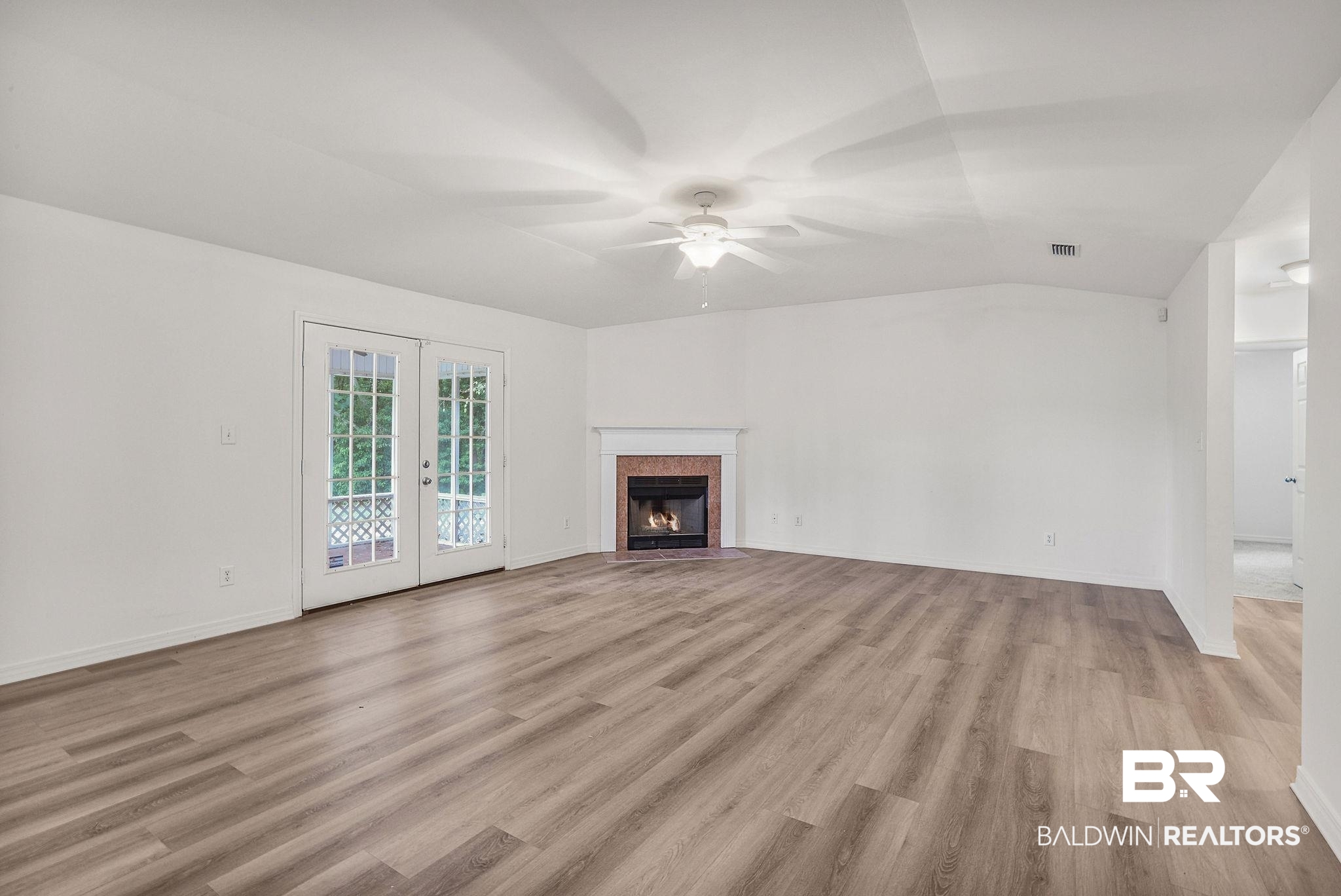 18620 Hammond Street Robertsdale, AL 36567 - Photo 4 of 23 Unfurnished living room featuring light hardwood / wood-style flooring, ceiling fan, vaulted ceiling, and french doors