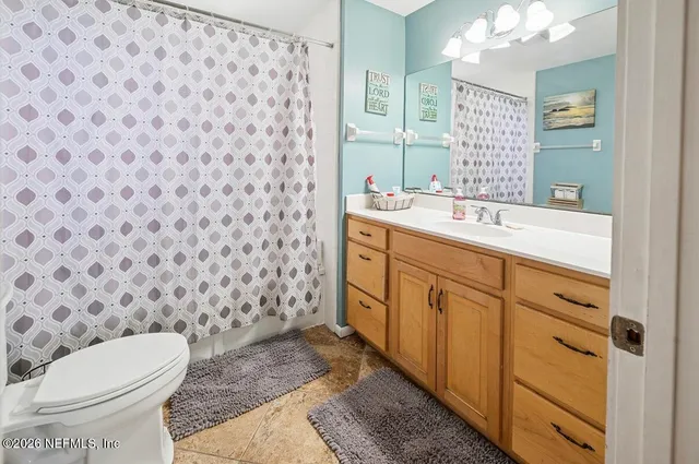 a bathroom with a granite countertop toilet sink and mirror