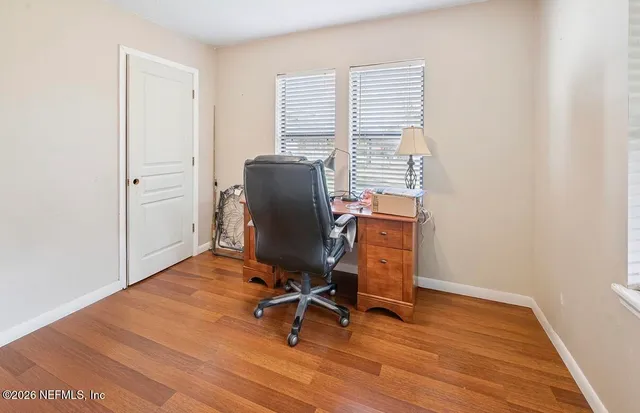 a view of a workspace with furniture and a window