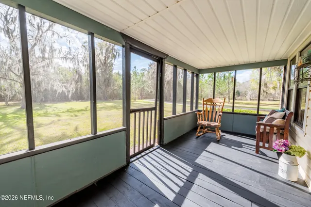 a bedroom with furniture and large windows