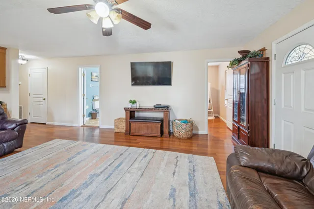 a living room with furniture and a wooden floor
