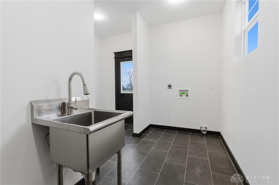 3509 South State Rte 72 Sabina, OH 45169 - Photo 21 of 44 This spacious laundry room offers a functional utility sink and ample space for chores.