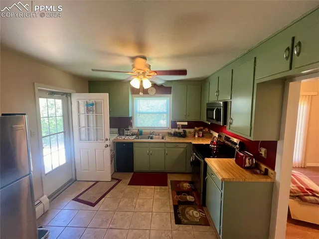 a kitchen that has a lot of cabinets and refrigerator in it