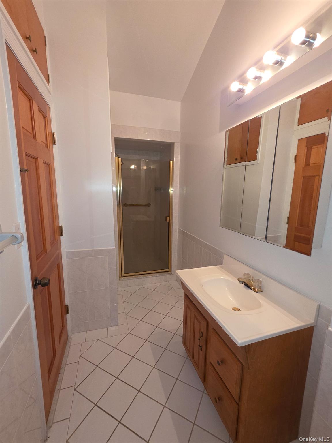 12-14 West 5th Road Queens, NY 11693 - Photo 12 of 43 Bathroom with vanity, a shower stall, light tile patterned floors, wainscoting, and lofted ceiling