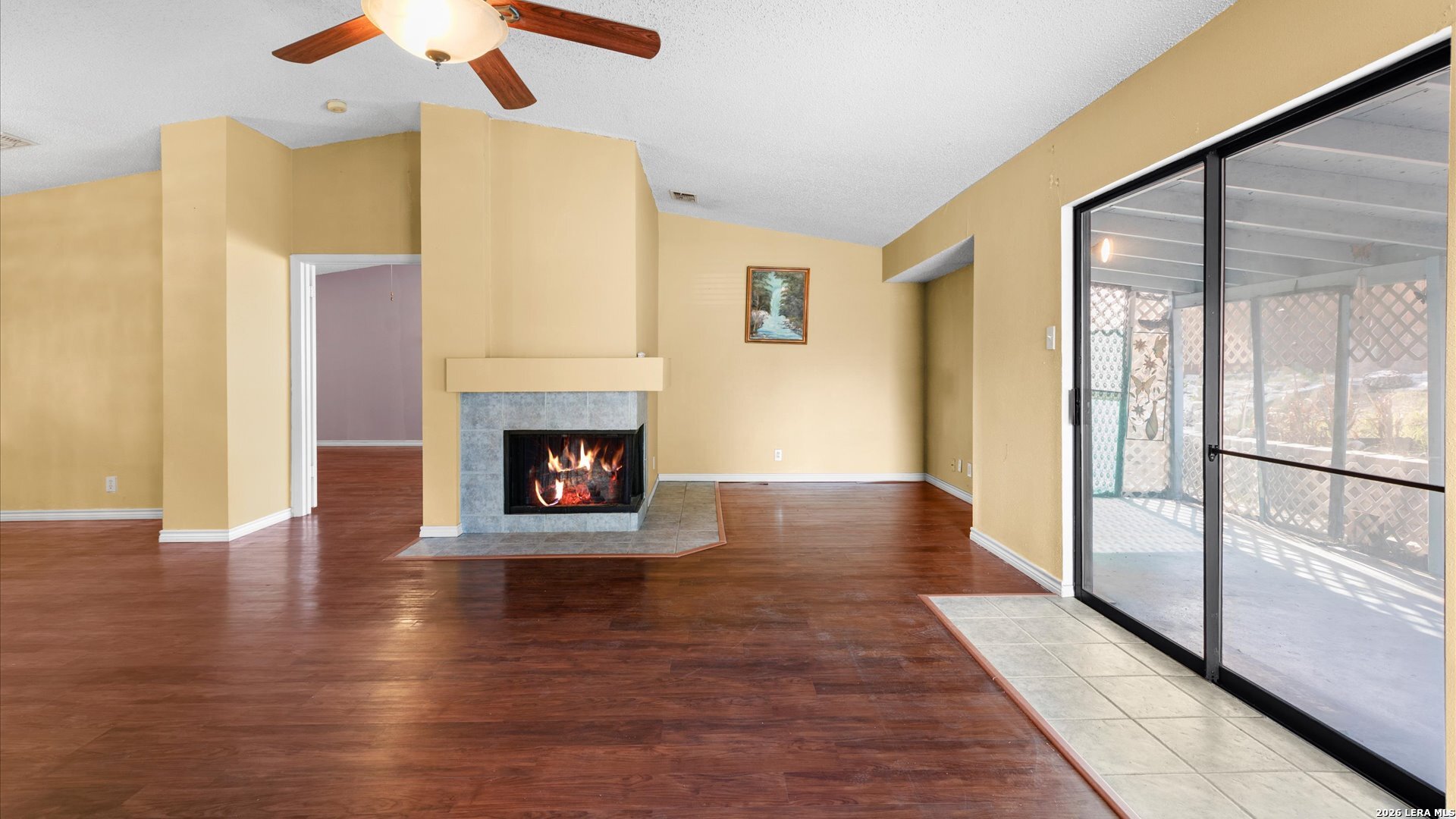 7339 Mystery Ridge Drive Converse, TX 78109 - Photo 6 of 23 a view of an empty room with wooden floor fireplace and a window