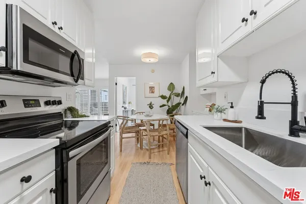 a kitchen with stainless steel appliances a sink stove and microwave