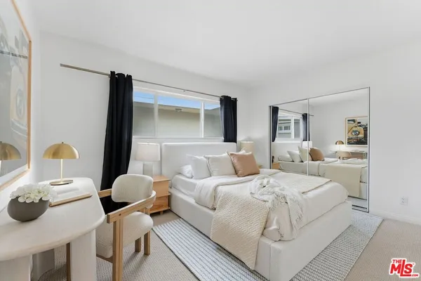 a bedroom with two beds and painting on the wall