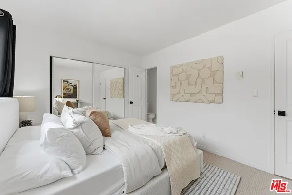 a bedroom with a bed and a painting on the wall