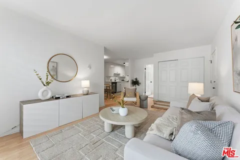 a living room with furniture a mirror and a lamp