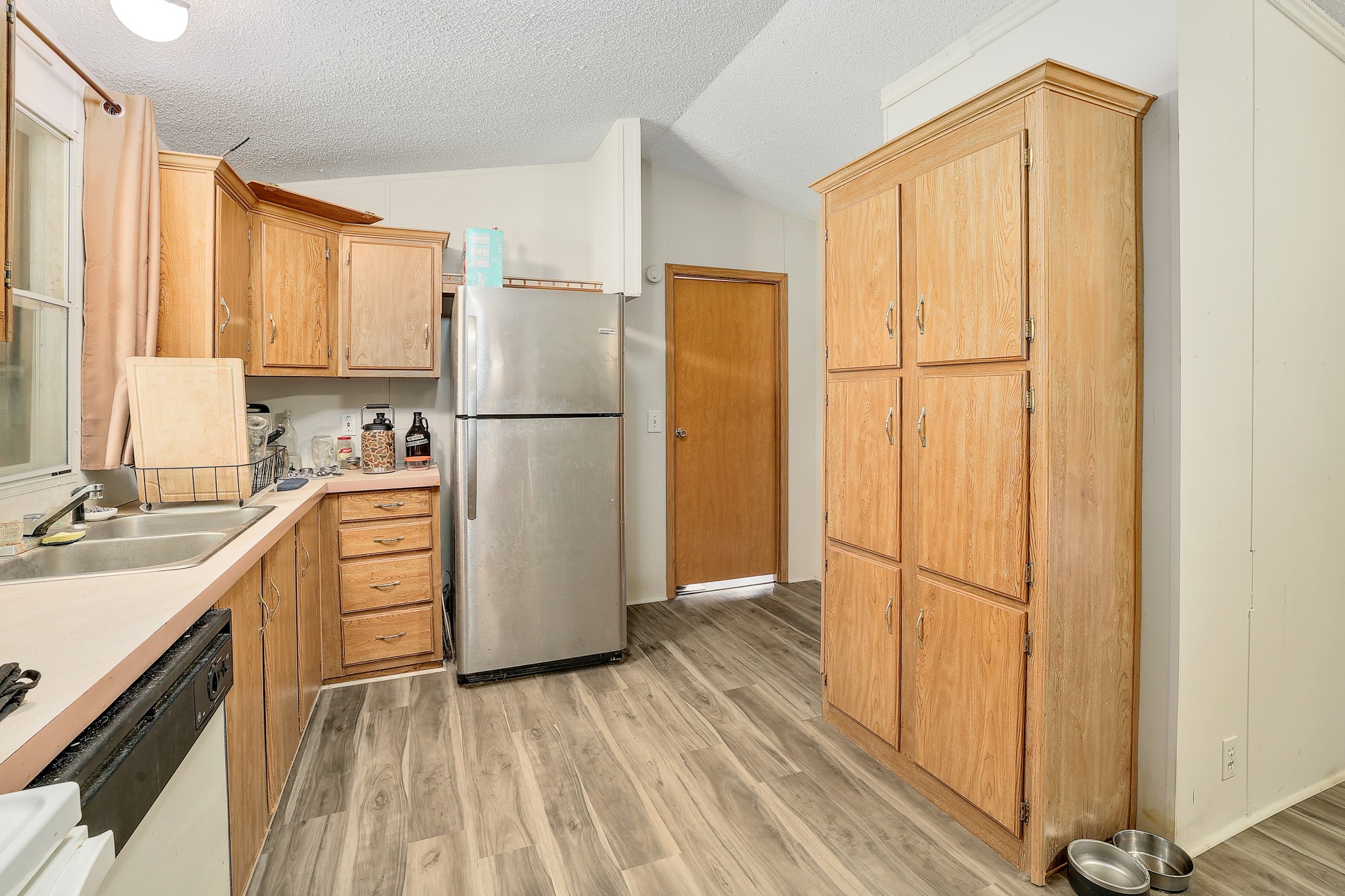 288 The Forest Road Dale, TX 78616 - Photo 10 of 31 a kitchen with a refrigerator a sink and dishwasher with wooden floor