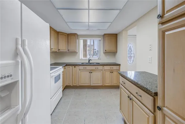 a kitchen with granite countertop white cabinets and white appliances