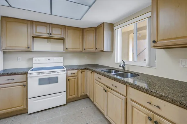 a kitchen with granite countertop cabinets stainless steel appliances and a sink