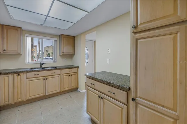a kitchen with granite countertop cabinets stainless steel appliances a sink and a window