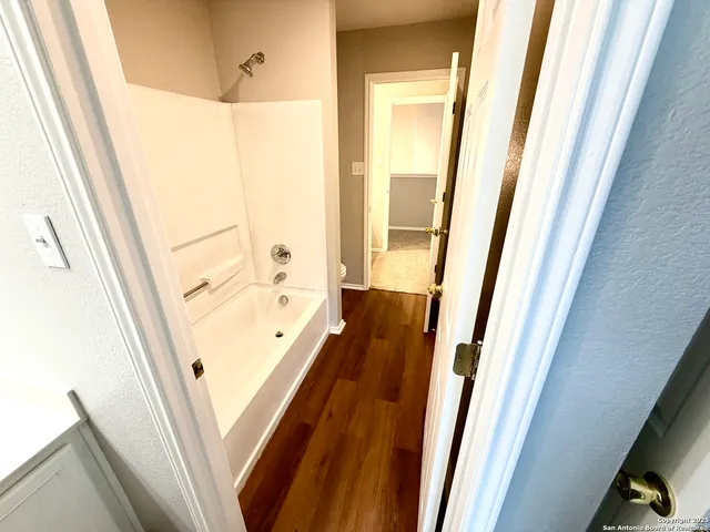 a view of a bathroom with a tub and door
