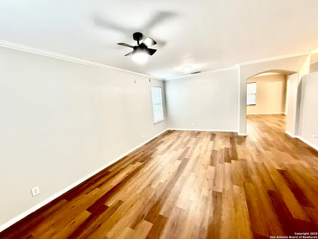 a view of empty room with wooden floor