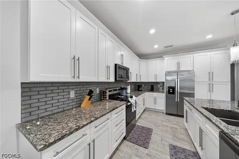 a kitchen with refrigerator stove microwave and sink