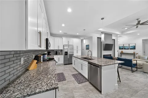a large kitchen with stainless steel appliances granite countertop a stove and a sink