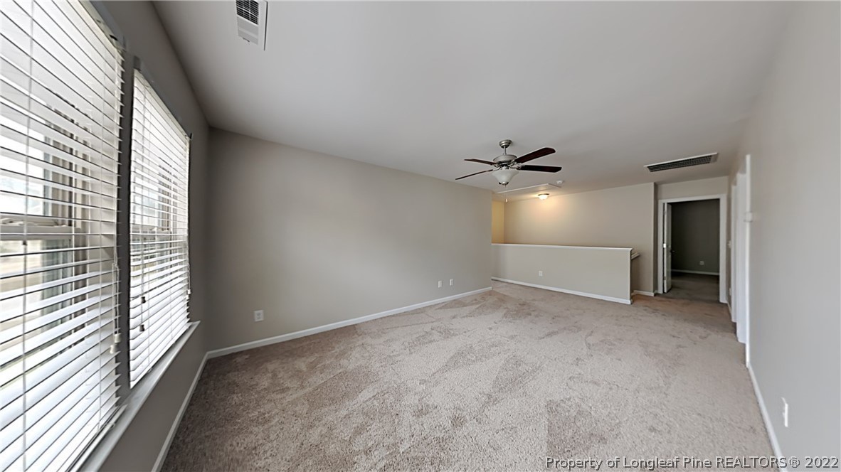 271 River Oak Street Spring Lake, NC 28390 - Photo 16 of 18 an empty room with windows and ceiling fan